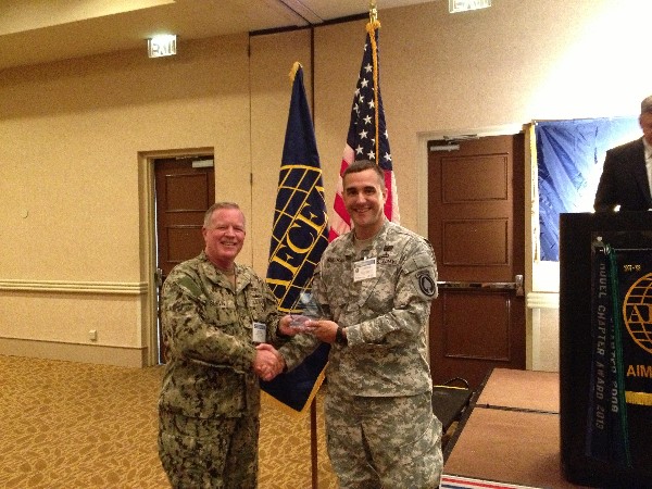 TAMPA-ST. PETERSBURG— Capt. Gerry Slevin, USN, chapter president (l) presents the AFCEAN of the Month to Maj. Chris Keeshan, USA, in July.